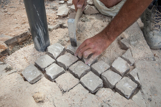 Bricklayer fixing portuguese pavement