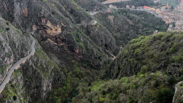 Aerial view of winding road through the deep Sagittario Gorges with rocky cliffs and lush vegetation in Anversa degli Abruzzi, Abruzzo, Italy.