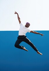 Obraz premium Energetic Young Black Man with Purple Hair Performing Dynamic Contemporary Dance Jump Against Blue and White Background