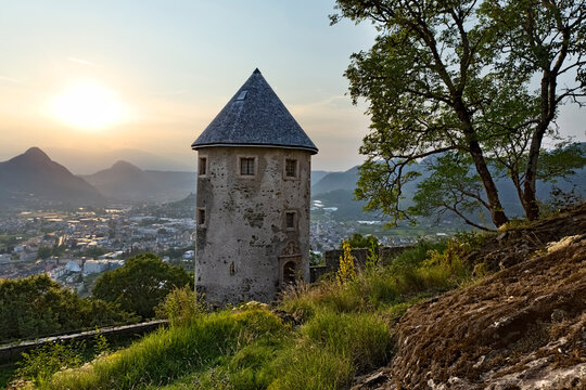 Pergine Castle: the cylindrical tower and a tree. In the background, the town of Pergine Valsugana. Trentino, Italy.