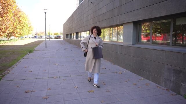 A woman gracefully strolling along contemporary architecture in a vibrant urban landscape