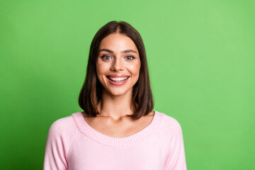 Fototapeta premium Young chic woman smiling wearing pink sweater against green background for lifestyle fashion advertising