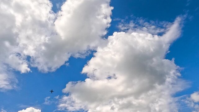 Airplane flying over fluffy clouds.
