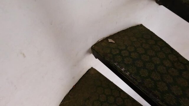 Worn spiral staircase with patterned steps.
