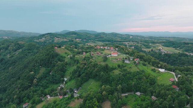 Aerial view of Kurija Hamor Samobor nestled among lush green hills and scattered rural houses in Samobor, Zagrebacka zupanija, Croatia.