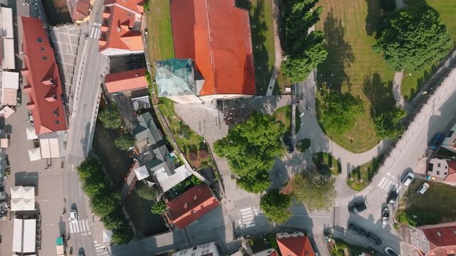 Aerial view of Kurija Hamor with its red roof and surrounding trees and people in the courtyard in Samobor, Zagrebacka zupanija, Croatia.