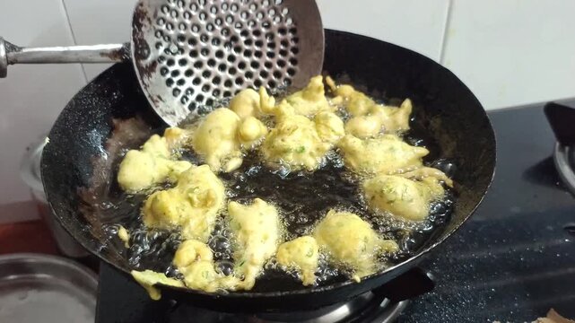 Deep Frying Indian Pakora Fritters in Hot Oil in Wok Kadhai Close Up
