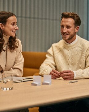 HR advisor and workplace manager preparing blank wellbeing resource cards in office meeting