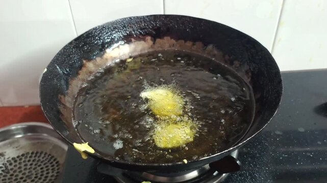 Deep Frying Indian Pakora Fritters in Hot Oil in Wok Kadhai Close Up