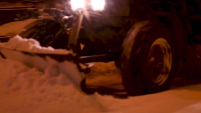 Large snow tractor at work on the evening streets of the city