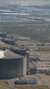 Aerial view of Dunkirk LNG Terminal with its large storage tank, industrial piping, and surrounding infrastructure in Loon-Plage, Hauts-de-France, France.