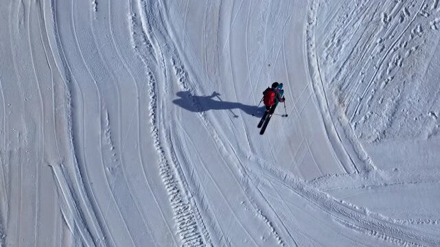 Aerial view of a skier gliding down a groomed snowy slope in the mountains of Nauders, Tyrol, Austria.