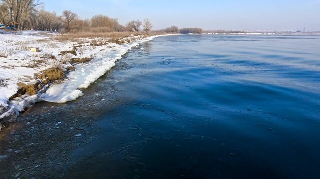 Snow river winter landscape. Frozen ice and snow by river.