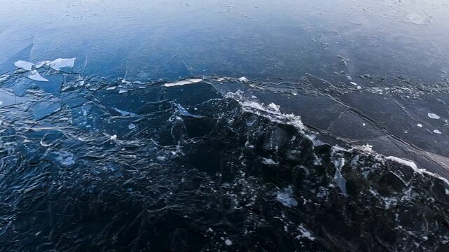 Waves from a boat sailing on a cold winter river