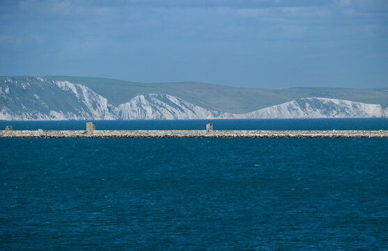 Portland Breakwater mit Blick auf den historischen Wellenbrecher im Hafen von Isle of Portland, die weltber&uuml;hmte Felsformationen der Jurassic Coast  im Hintergrund, im Sommer