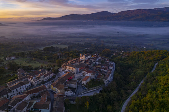 Aerial view of the historic town of San Giuliano del Sannio nestled in the hills of Molise at sunrise with golden light hitting the rooftops and church, San Giuliano del Sannio, Molise, Italy.