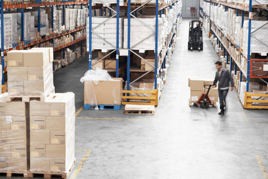 Logistics, box and pallet jack with people in warehouse for distribution, freight or supply chain. Export, delivery and cargo storage with above of employees for customs compliance in inventory check