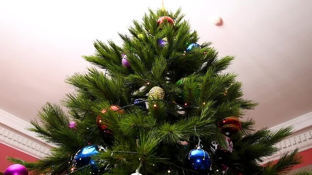 A Christmas tree decorated with various toys, garlands and lights hanging from its branches.