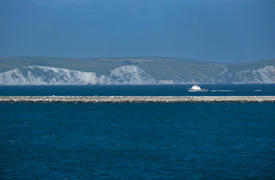 Portland Breakwater mit Blick auf den historischen Wellenbrecher im Hafen von Isle of Portland, die weltber&uuml;hmte Felsformationen der Jurassic Coast  im Hintergrund, im Sommer