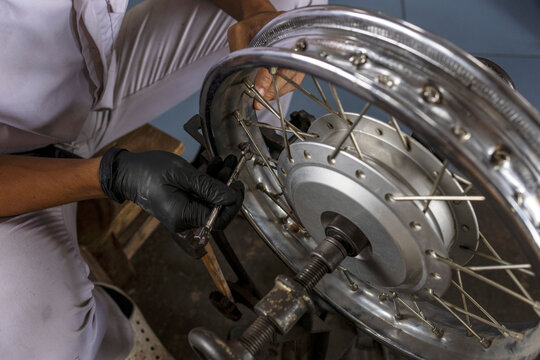 Motorcycle Wheel Maintenance by Professional Mechanic in Repair Workshop