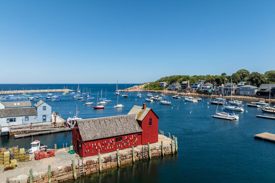 Aerial view of the iconic red fishing shack known as Motif Number 1 surrounded by sailboats in the harbor and lobster traps on the pier in Rockport, Massachusetts, United States.