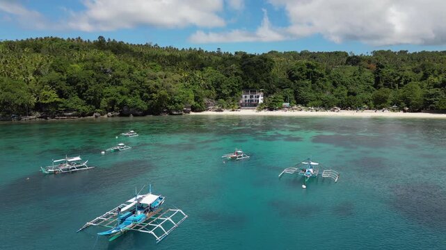 Local Fishing Boats Rest In Turqoise Water Off Crystal Beach Samal Island Davao Philippines Drone Track Right 4K 30FPS