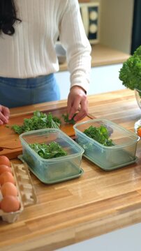 Woman Preparing Healthy Meal Prep with Fresh Kale and Eggs in Kitchen