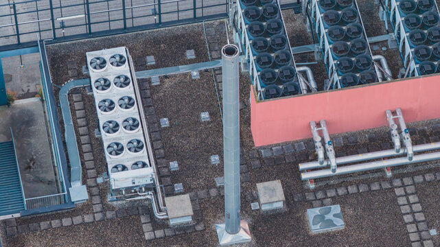 Aerial view of industrial cooling infrastructure featuring rooftop dry coolers, HVAC systems, and mechanical piping on a building in Valence, Auvergne-Rhone-Alpes, France.