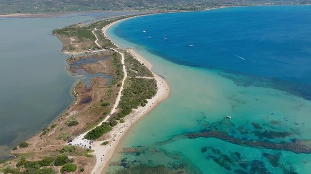 Chrisi Ammos beach near Voidokilia, Pylos, Greece, aerial panorama. Colorful umbrellas, swimmers, crystal clear water. Sunny summer day
