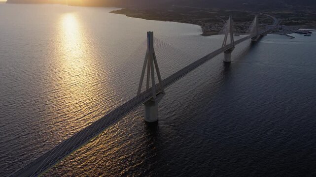 Charilaos Trikoupis Rio Antirrio Bridge spans over Rion Strait connecting the Gulf of Corinth and Gulf of Patras at sunset, Rio, Antirrio, High angle drone shot