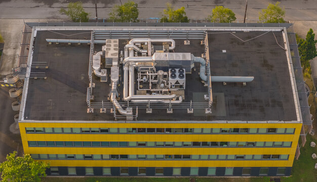 Aerial view of rooftop HVAC equipment, ventilation ducts and cooling systems installed on a modern office building in Valence, Auvergne-Rhone-Alpes, France.