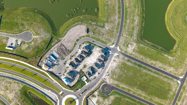 Aerial view of a new residential housing development under construction with paved roads, cul-de-sacs, and surrounding retention ponds in Parrish, Florida, United States.
