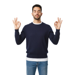 Naklejka premium Young hispanic man with dark curly hair and beard, wearing navy sweater and blue jeans, meditating with Gyan Mudra on a bright white studio background, deep inner peace atmosphere.