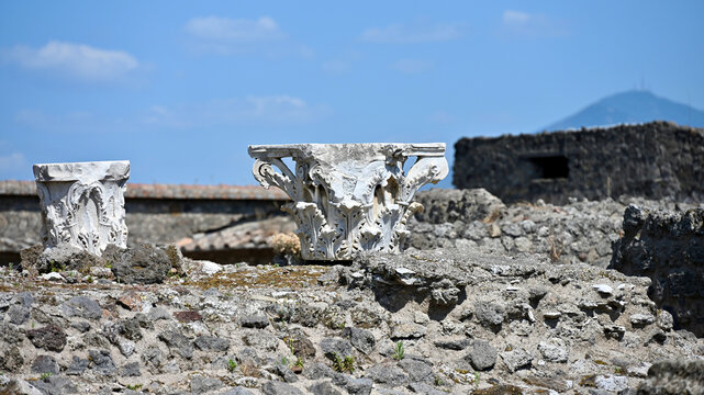 Ancient Corinthian Architectural Capital on Stone Wall with Other Structures and Vesuvius in Background, Pompeii Archaeological Site