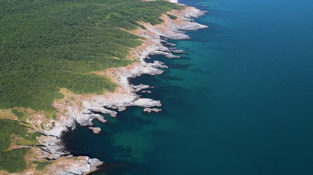 Aerial Top-Down View of Rocky Coastline and Deep Blue Sea Water