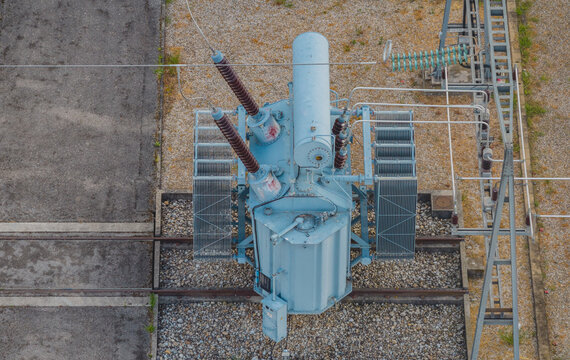 Aerial view of a high-voltage electrical transformer and switching equipment inside a modern power substation in Valence, Auvergne-Rhone-Alpes, France.