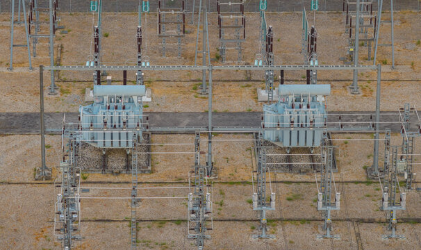 Aerial view of a high-voltage electrical substation featuring twin power transformers, switchgear and transmission infrastructure in Valence, Auvergne-Rhone-Alpes, France.
