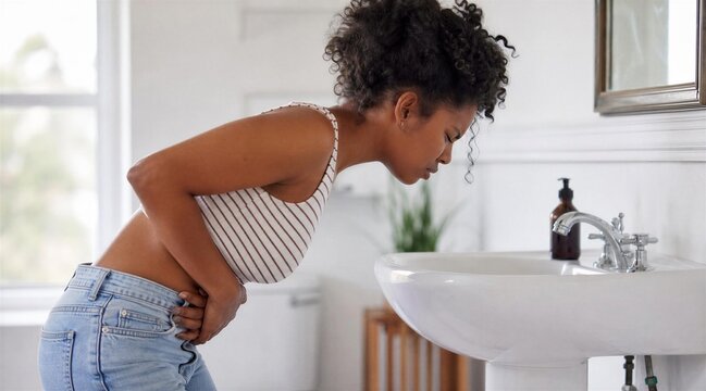 Young Black Woman With Stomach Pain Bent Over Bathroom Sink