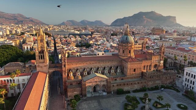 Palermo Cathedral medieval landmark bathed in early morning sunlight, aerial view of historic center in Sicily. Golden sunrise over Palermo Cathedral with cityscape and mountains, Sicily, Italy