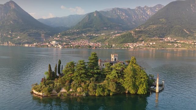 Aerial view of Isola di Loreto island with neo gothic castle on Lake Iseo. Small fairytale island with historic villa in Northern Italy - Isola di Loreto. Lake Iseo, Lombardy region, Italy