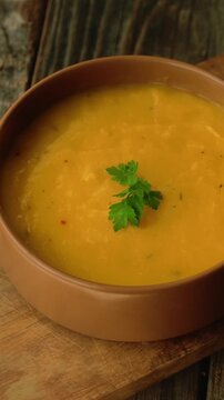 Vertical video. Bowl of pumpkin soup. Tradition autumn food, vegetable cream soup. 