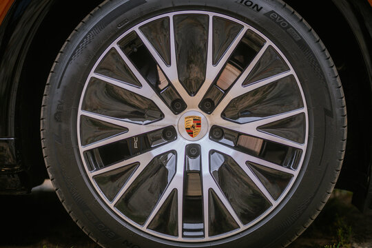 Close-up view of a Porsche alloy wheel showcasing intricate design and logo, highlighting the tire and rim details
