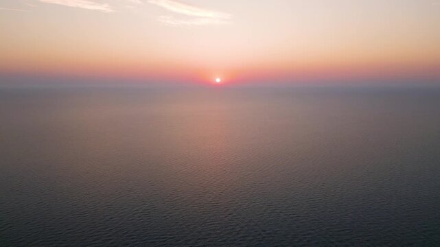 High Aerial View of Golden Sunrise Sunset Over Open Sea Water Horizon