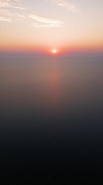 High Aerial View of Golden Sunrise Sunset Over Open Sea Water Horizon