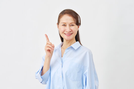 白背景で左側を指差す女性
