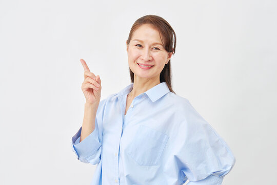 白背景で左側を指差す女性
