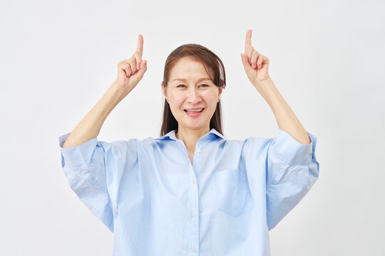 白背景で上を指差す女性