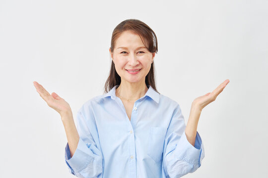 白背景で手のひらで両側を指す女性