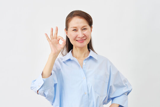 白背景でOKサインをする女性