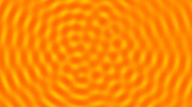 Blurred orange and yellow pattern of concentric circles and waves